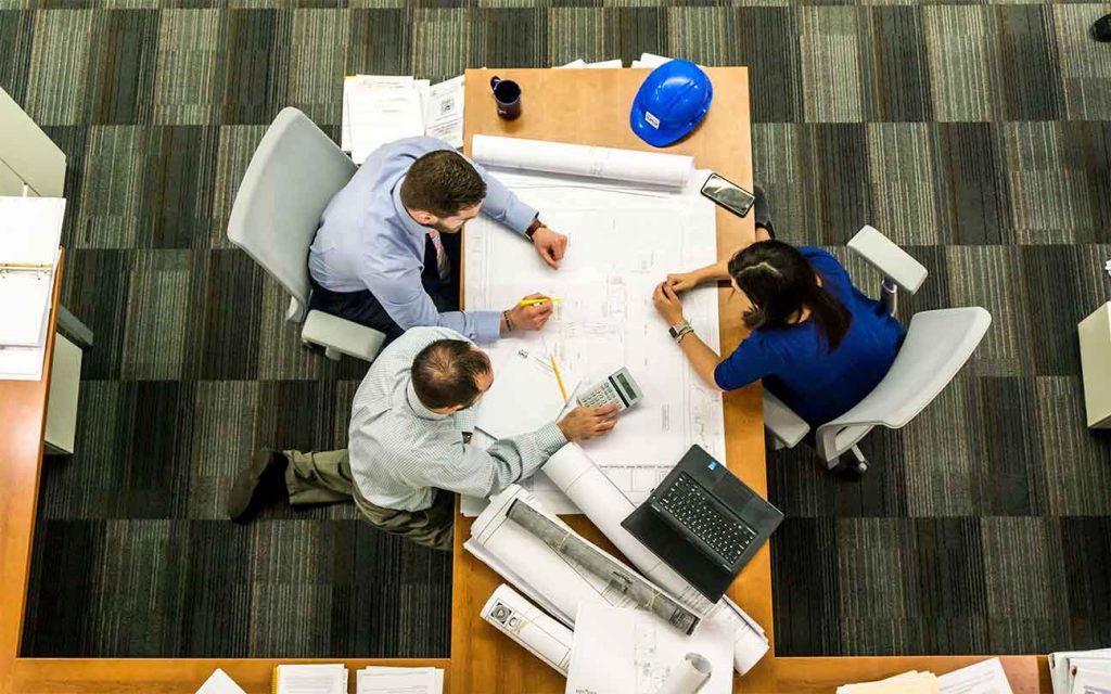 Equipo de trabajo en reunión de revisión de planos de una construcción