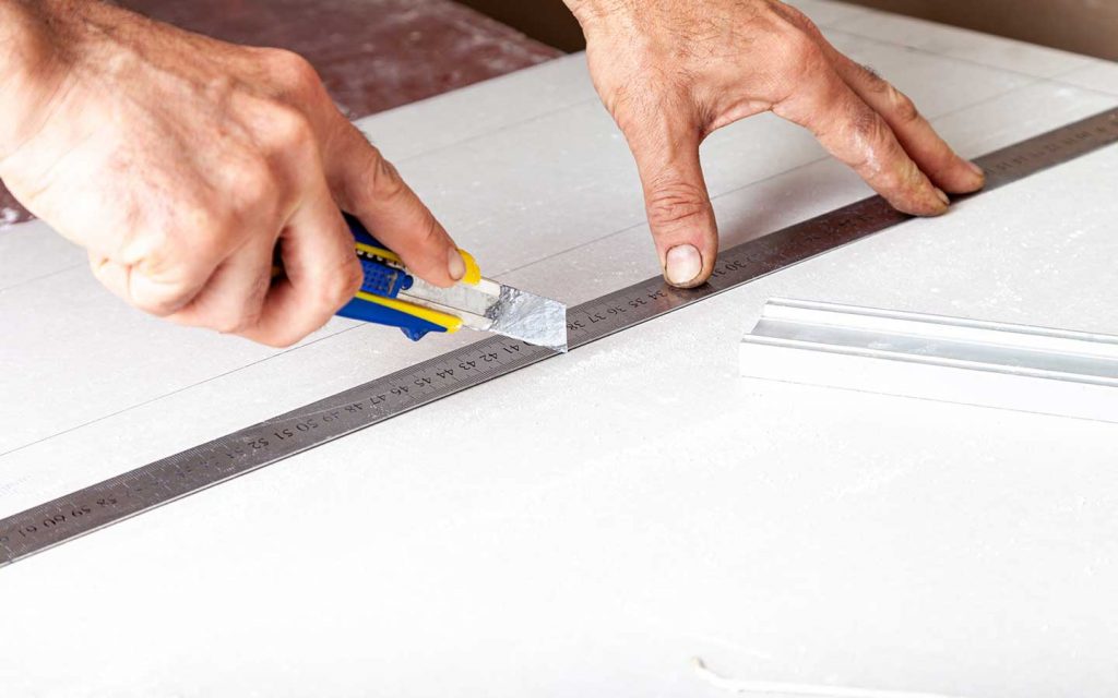 Medidas y corte de la pieza de reemplazo para tapar un hueco en la pared de drywall